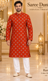 Ram Orange adult model wearing the embellished kurta and white polo pajama set in the Saree Duniya showroom.
