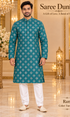 Ram Turquoise adult model wearing the embellished kurta and white polo pajama set in the Saree Duniya showroom.