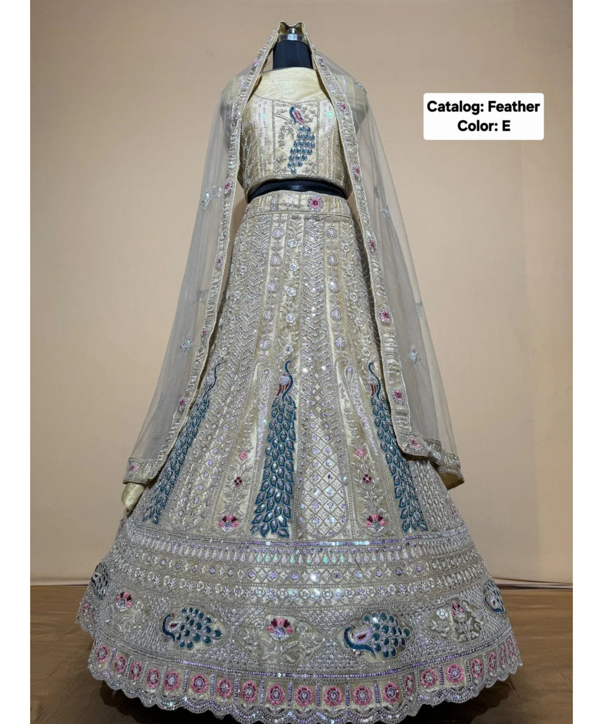 Feathers — E – Champagne; original photograph showing the semi-stitched size 44 lehenga and unstitched blouse fabric with peacock embroidery.
